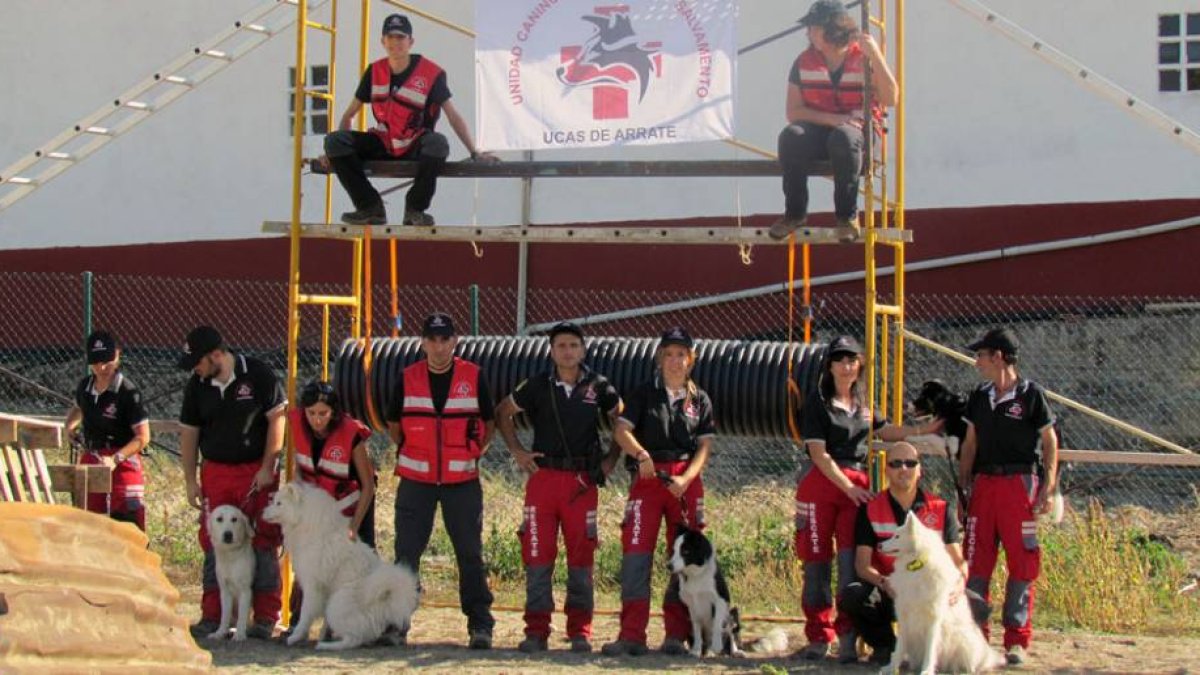 Los instructores de la Unidad Canina de Rescate posan orgullosos con sus perros, héroes caninos cuya ayuda es inestimable.-UCAS