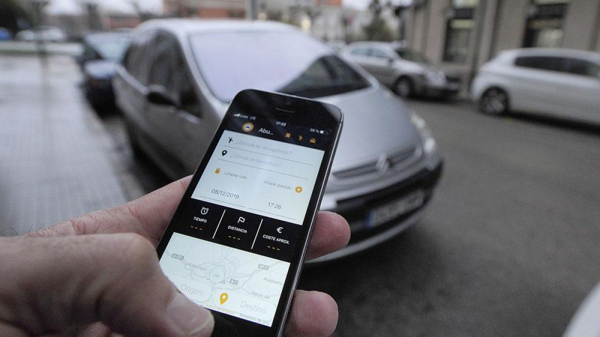 Un usuario reserva un taxi a través de la nueva aplicación Abutaxi.-ISRAEL L. MURILLO