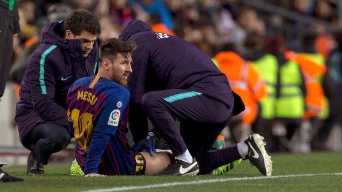 Messi recibe un masaje en el muslo derecho tras quejarse de unas molestias en la segunda mitad del Barça-Valencia.-QUIQUE GARCÍA (EFE)