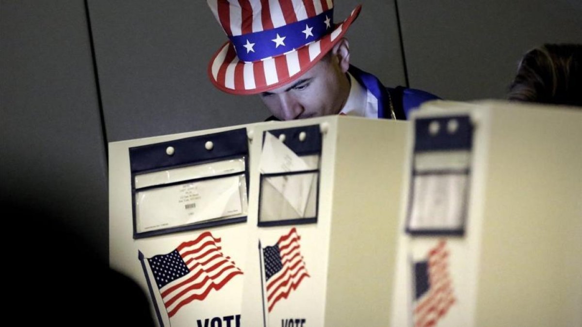 Un hombre vestido como el Tio Sam ejerce su derecho al voto en un centro electoral en el eastside de Nueva York en las eleccines presidenciales del 2016.-/ EFE / PETER FOLEY