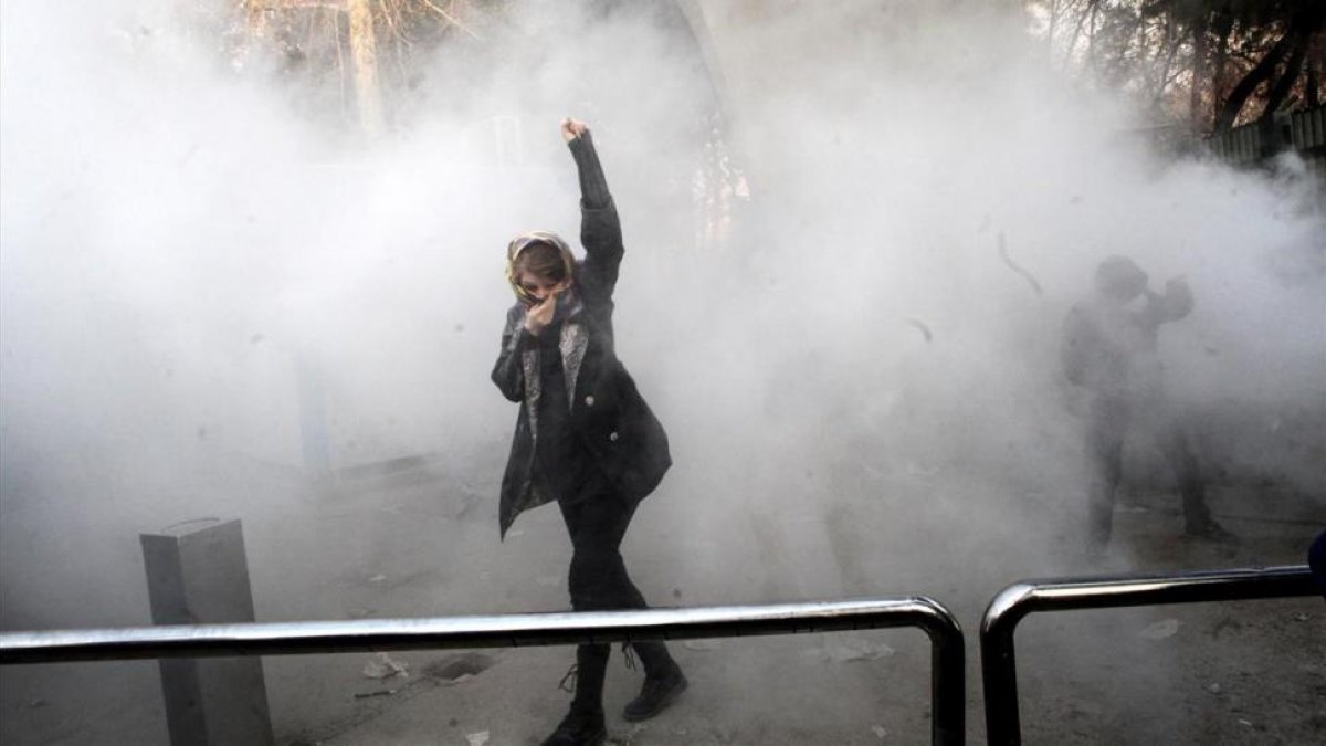 Estudiantes iranís se enfrentan a la policía frenta a la Universidad de Teheran este sábado.-EFE
