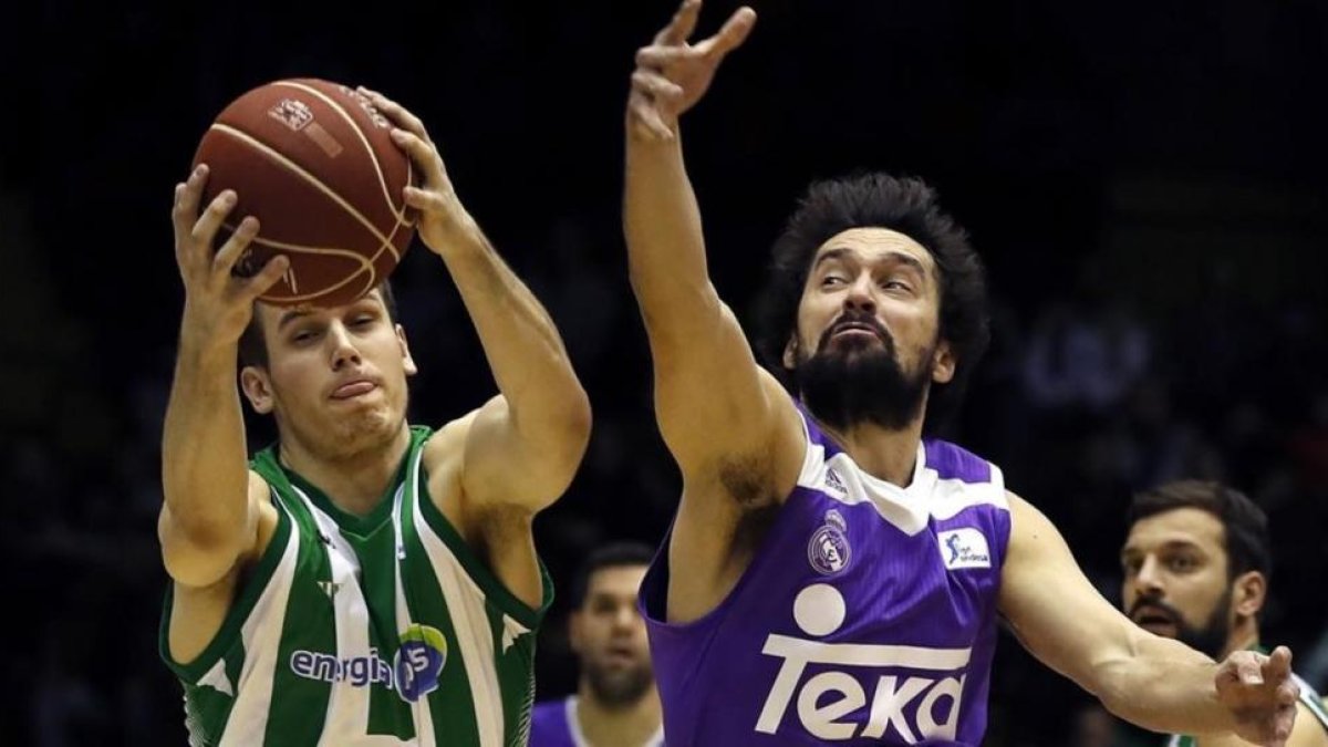 El base del Betis Radicevic pugna con Llull, del Madrid.-EFE / JULIO MUÑOZ