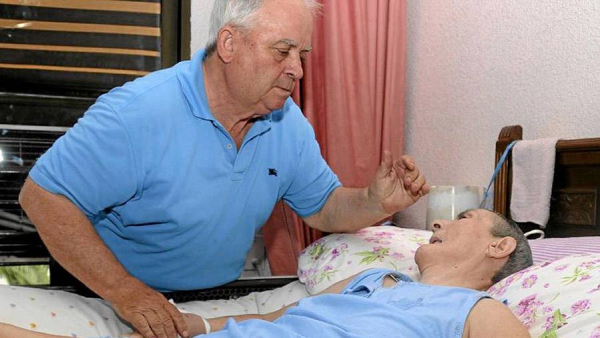 Un jubilado atiende a su mujer, dependiente, en su domicilio.-CRISTÓBAL MANUEL