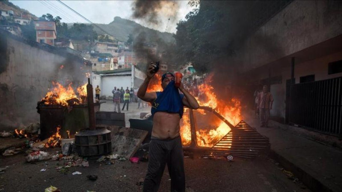 Un grupo de personas se manifiesta en una calle de Carcas (Venezuela).-MIGUEL GUTIERREZ (EFE)