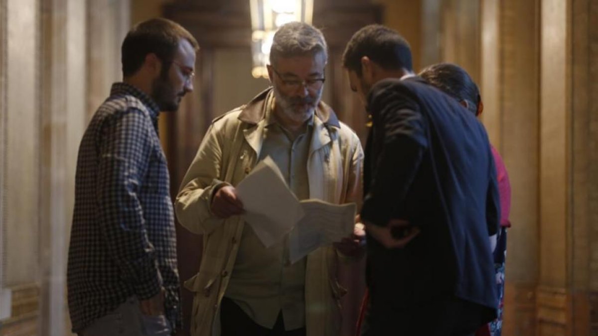 El diputado de JxSí, Roger Torrent, muestra unos documentos a los parlamentarios de la CUP Albert Botran y Carles Riera.-ALBERT BERTRAN