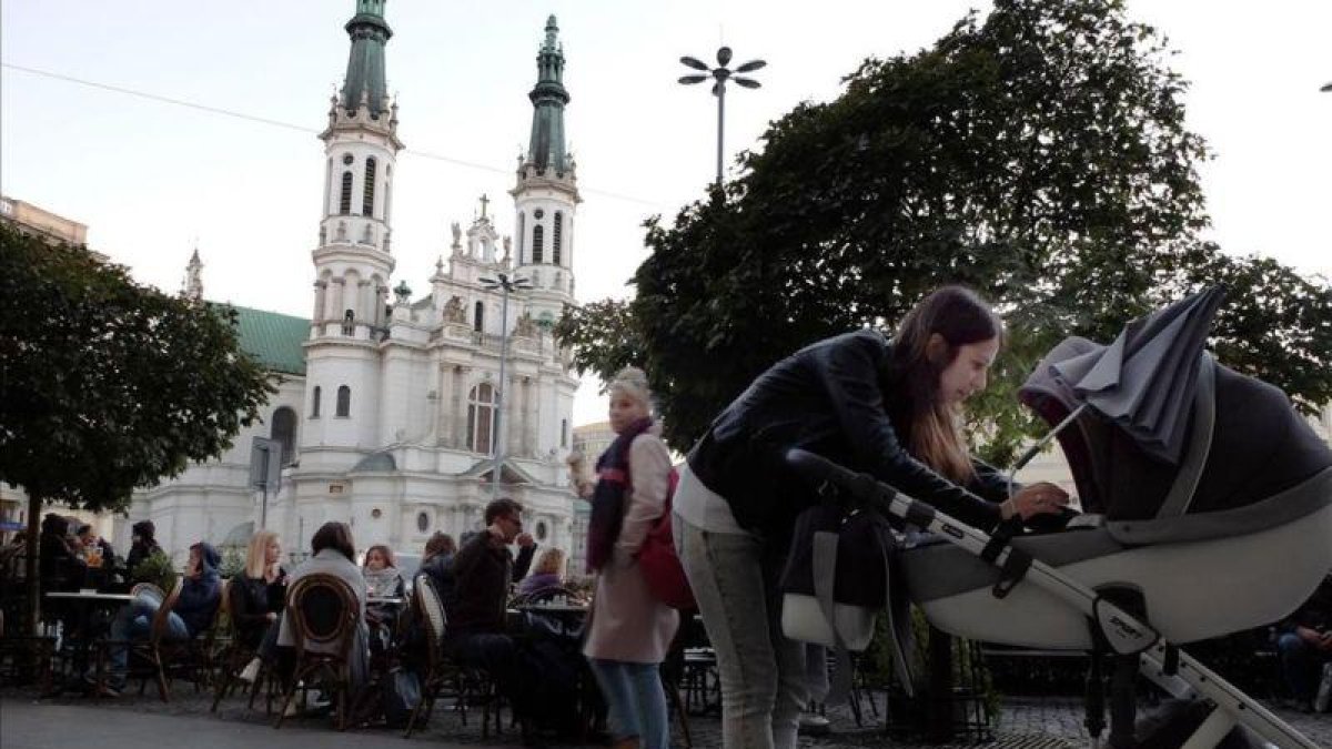 Un grupo de jóvenes en la terraza de una cafetería de la plaza Zbawiciela, en el centro de Varsovia.-KIM AMOR