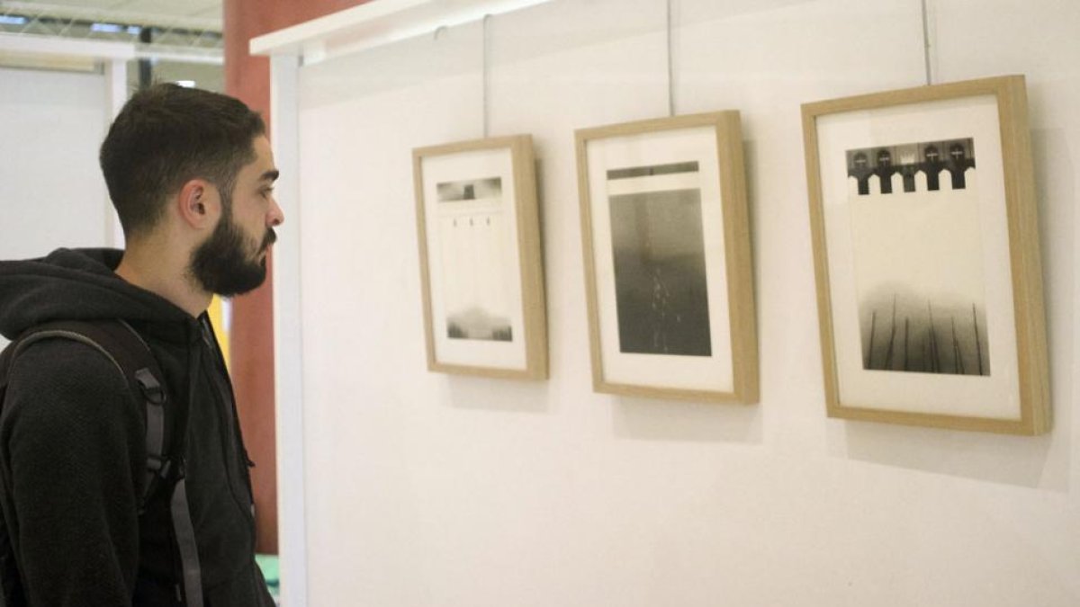 Un estudiante observa tres de las pinturas ‘del interior’ que reflejan los muros que construyen los países ante la pasividad de sus ciudadanos.-Sergio Isar