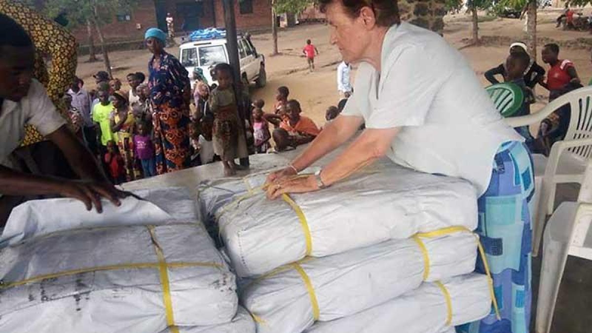 La hermana Presentación organiza el reparto de lonas de plástico.-ECB