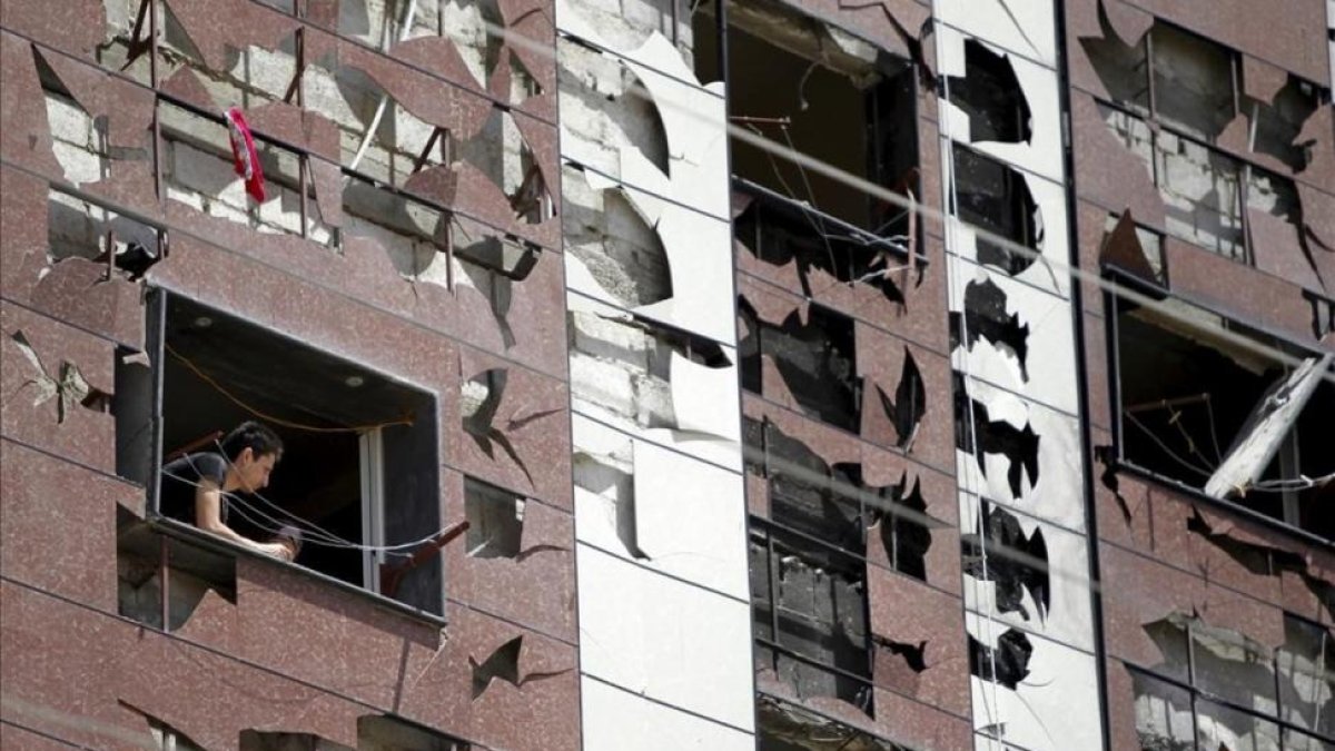 Edificio dañado por la explosión de un coche bomba en un barrio al sur de Damasco, Síria.-OMAR SANADIKI
