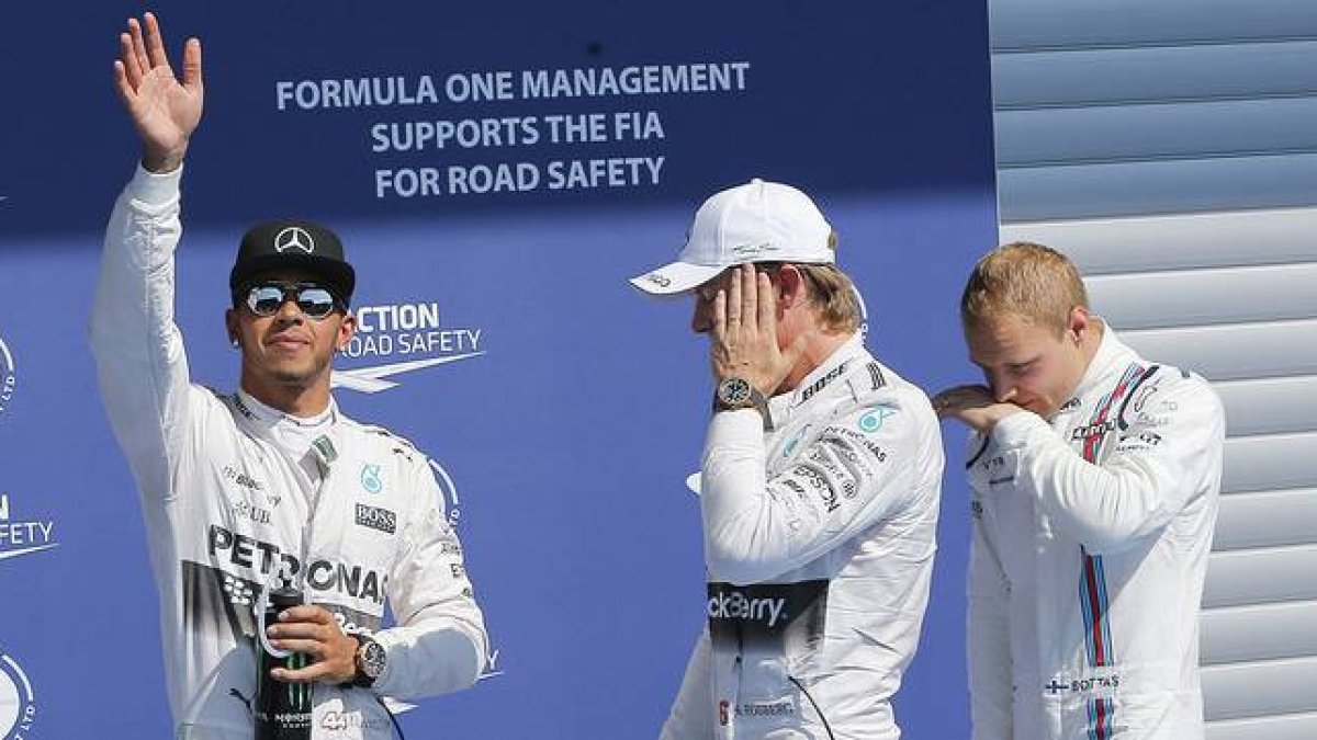 Lewis Hamilton, 'pole' en Spa, saluda a los aficionados junto a Nico Rosberg y Valtteri Bottas.-Foto: EFE / VALDRIN XHEMAJ