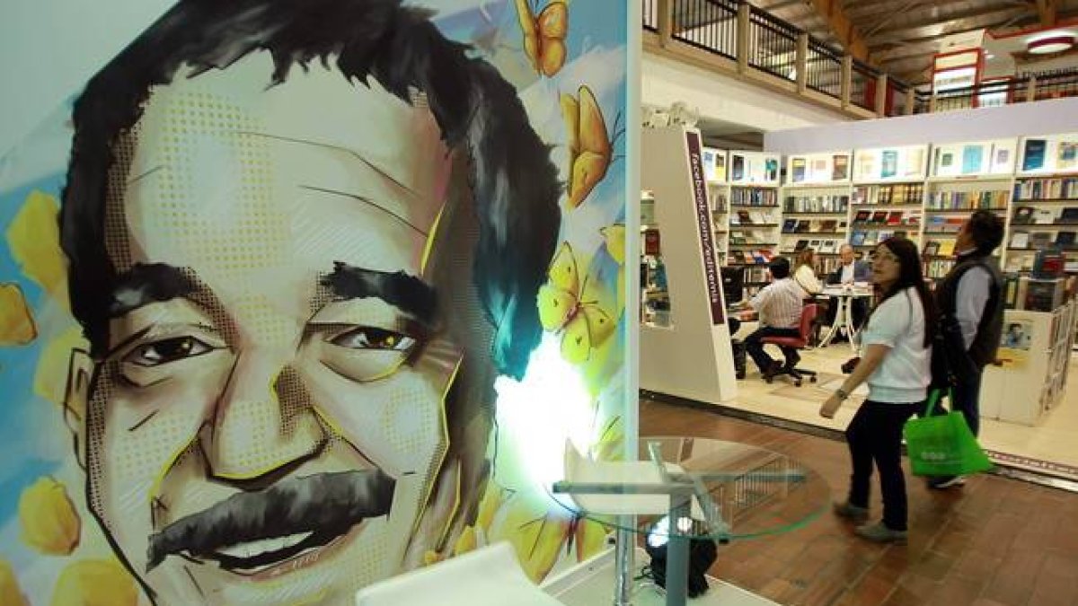 Una pareja pasa frente a una ilustración de Gabriel García Márquez en la Feria Internacional del Libro de Bogotá.-Foto: EFE / MAURICIO DUEÑAS