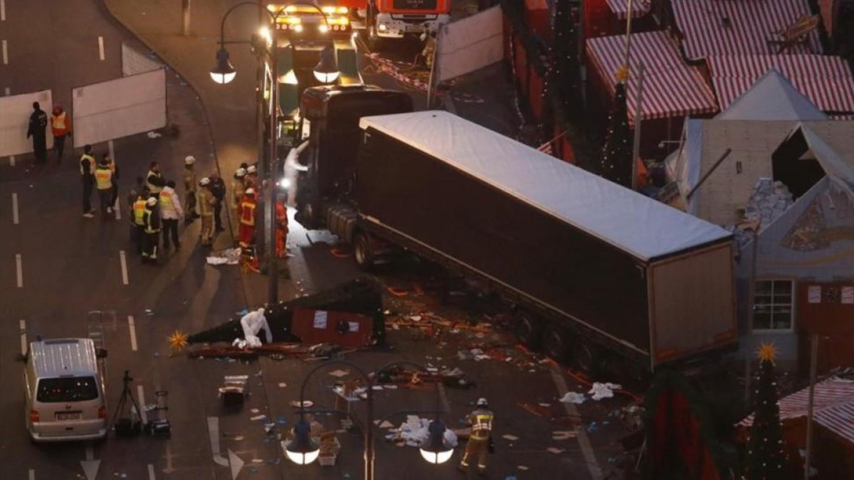 Expertos forenses examinan los destrozos tras la irrupción del camión contra el mercadillo navideño de Berlín, el 20 de diciembre del 2016.-AFP / ODD ANDERSEN