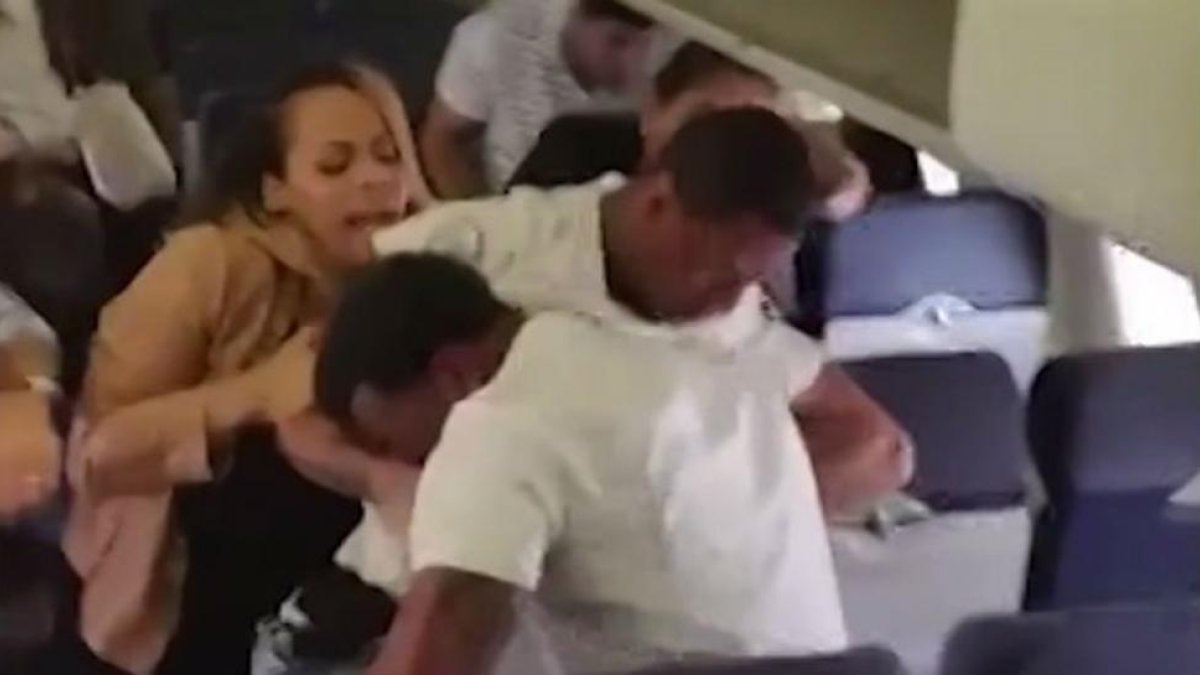 Una mujer intenta separar a los dos individuos que se enzarzaron en un avión de Southwest.-CNN