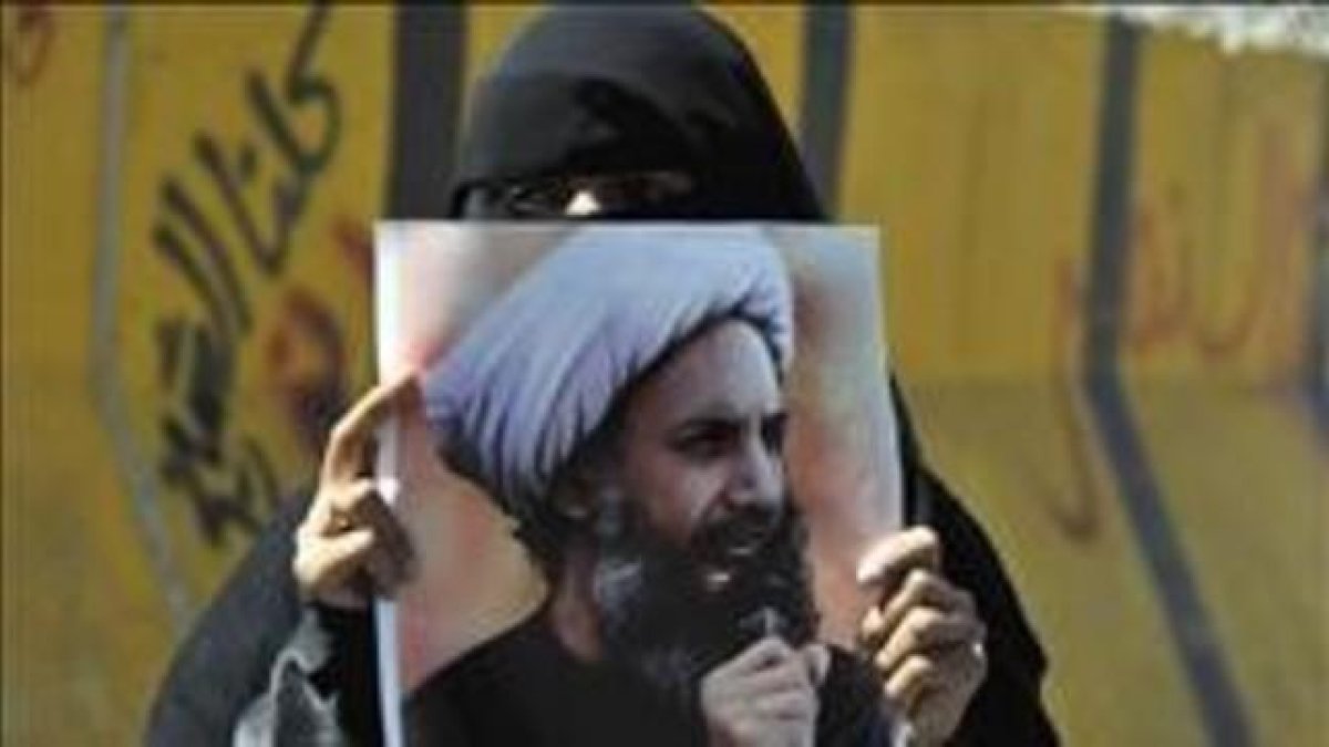 Una mujer sostiene en Yemen la foto del clérigo chií Al Nimr ajusticiado.-EFE / YAHYA ARHAB