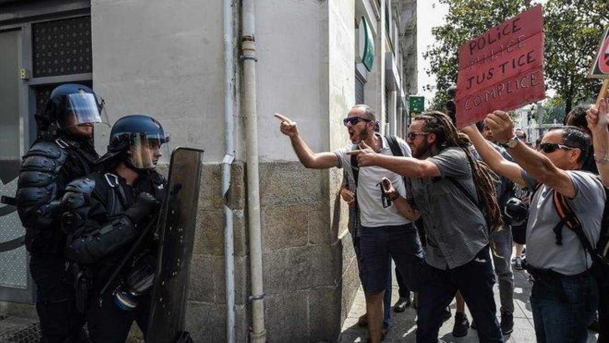 Unos manifestantes increpan a los antidisturbios.-AFP