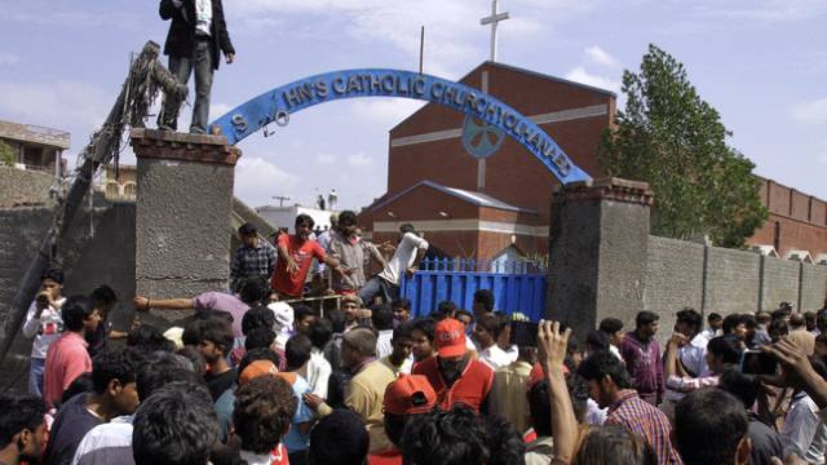 Los cristianos paquistanís y los equipos de rescate se reúnen fuera de una iglesia dañada por un ataque suicida.-Foto: K.M. CHAUDARY / AP