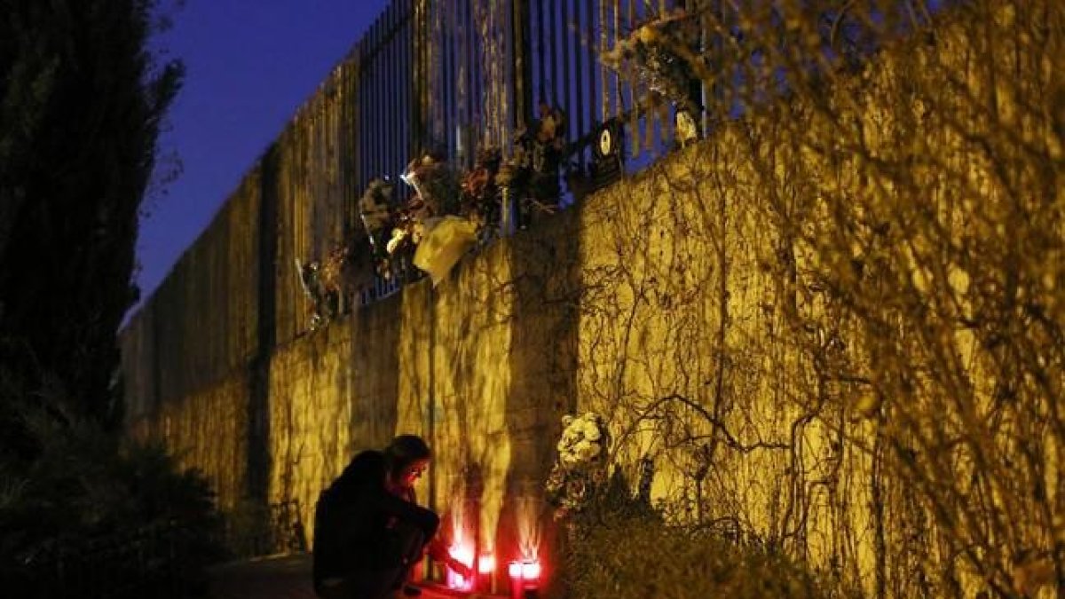 Una mujer enciende velas fuera de la estación de Atocha de Madrid en el undécimo aniversario del atentado del 11-M-REUTERS