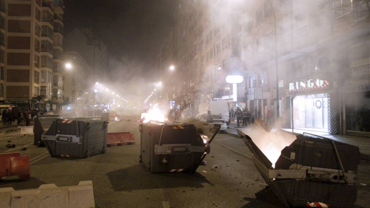Primera noche de disturbiso, con contenedores quemados y cristales de sucursales bancarias reventados.-SANTI OTERO