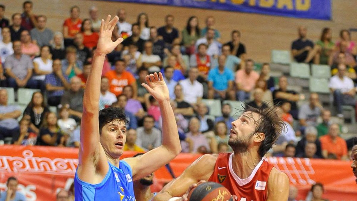 Huskic intenta frenar al jugador del Murcia Delía.-ACB PHOTO / J. BERNAL