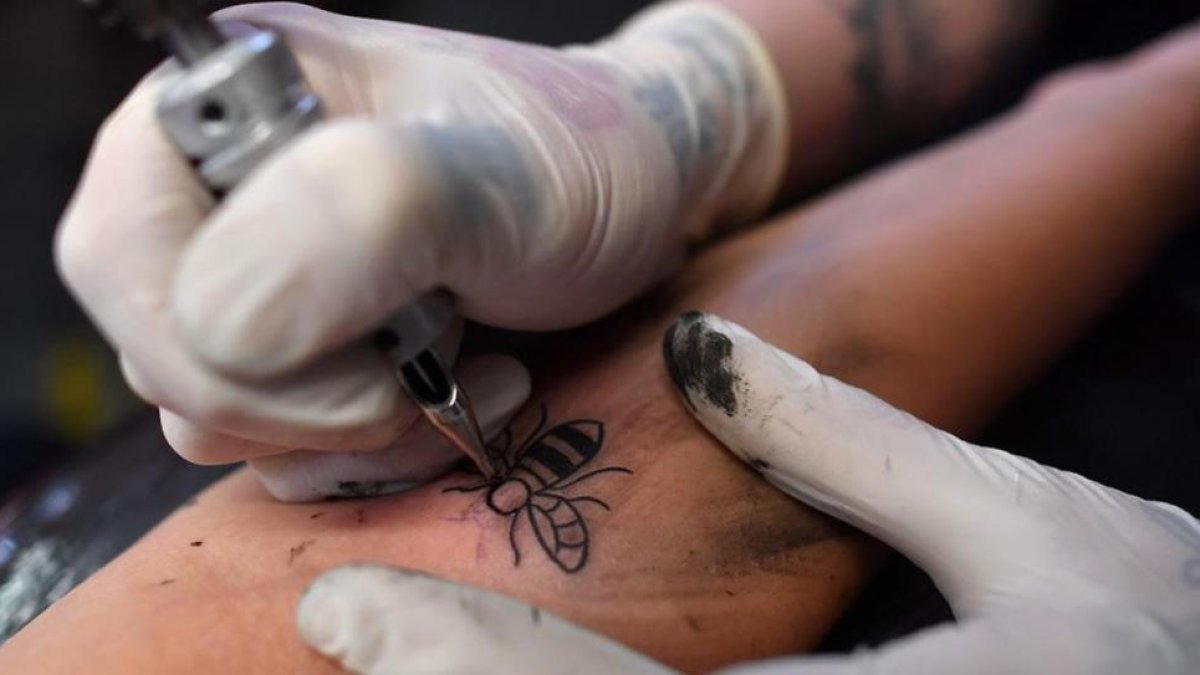 Tatuando una obeja obrera en Manchester.-BEN STANSALL / AFP