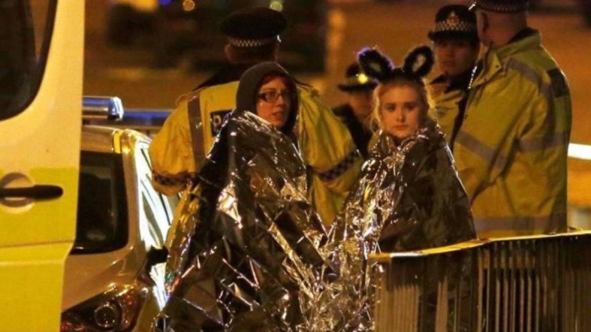 Dos chicas son atendidas por los servicios de emergencia a las afueras del Manchester Arena.-REUTERS
