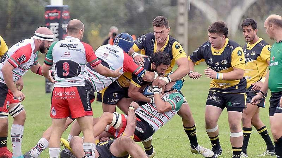 Juan Aristemuño avanza con el oval ante la oposición de varios jugadores del Hernani.-AREA 11