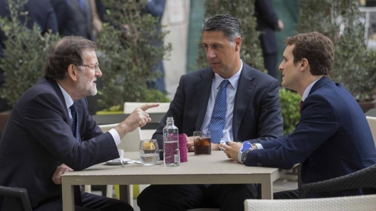 El presidente del Gobierno, Mariano Rajoy, con el vicesecretario de comunicación del PP, Pablo Casado, y el líder del PPC, Xavier García Albiol. / TAREK-