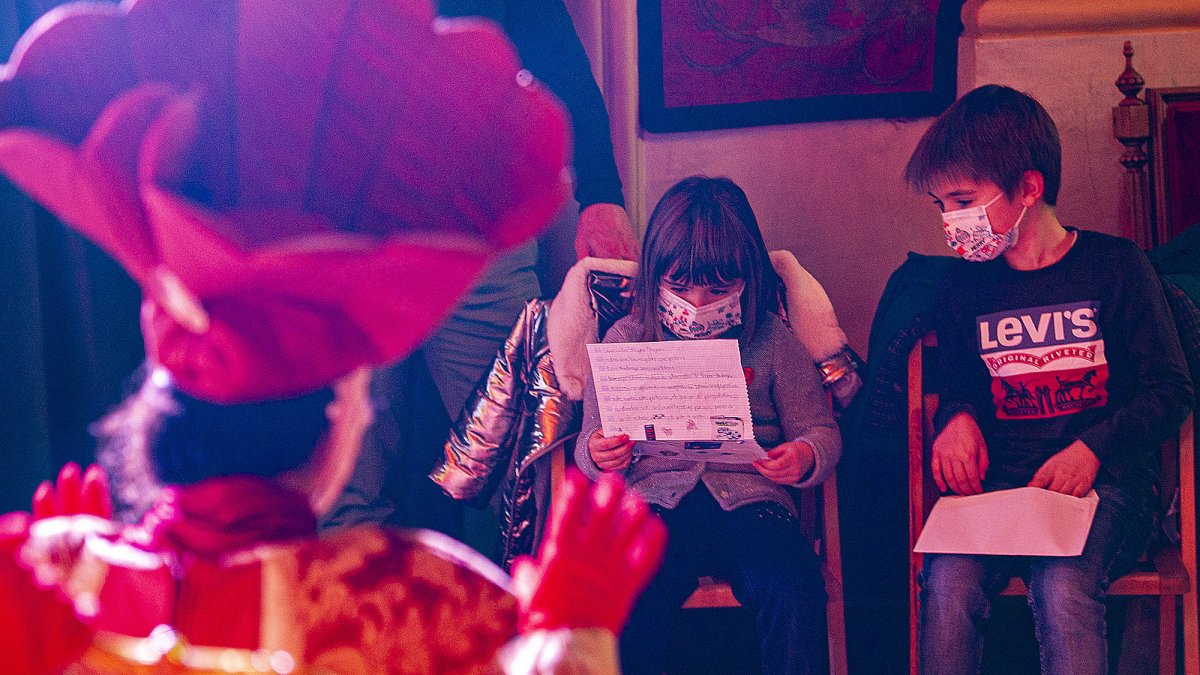 Una niña lee su carta a los Reyes Magos ante los emisarios del Rey Melchor que reciben a los pequeños en el Salón Rojo. ISRAEL L. MURILLO