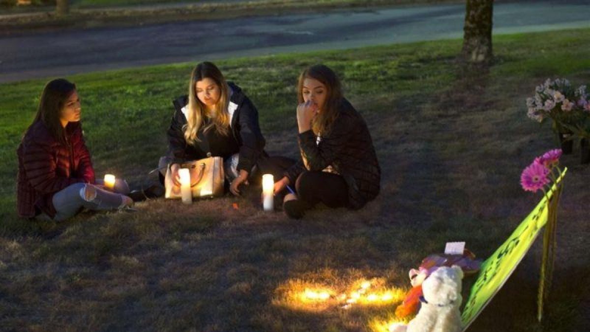 Unas jóvenes encienden velas en memoria de las víctimas del tiroteo en Burlington.-AFP / GETTY / KAREN DUCEY