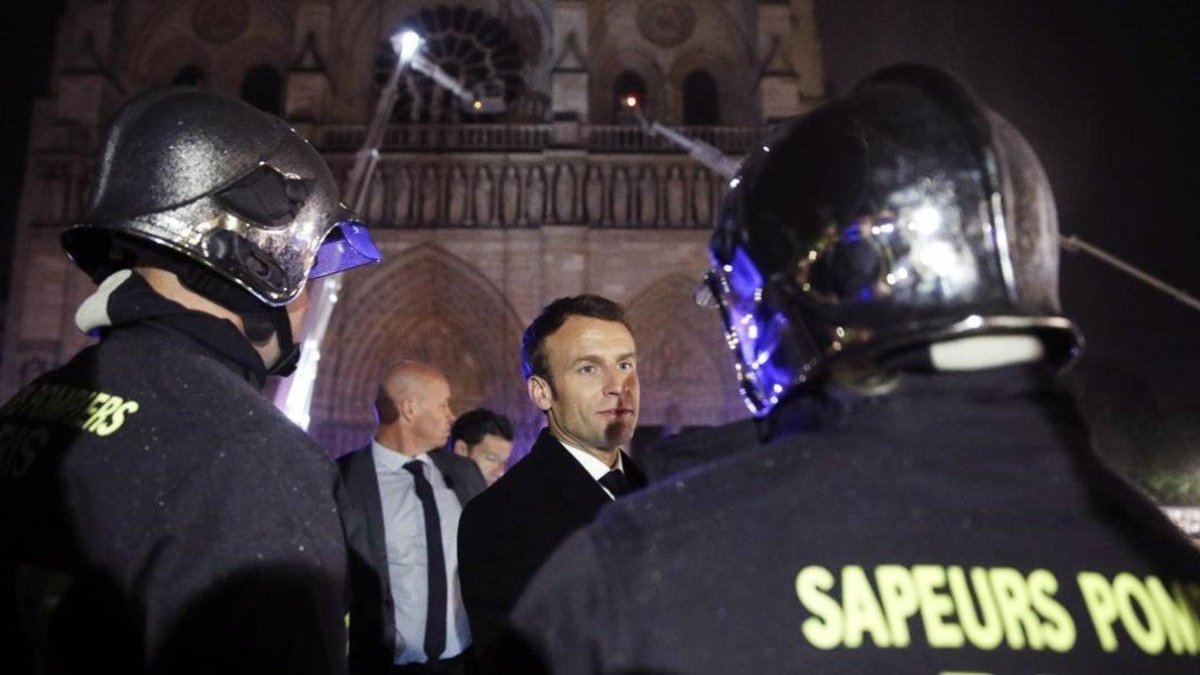 El presidente de Francia Emmanuel Macron, habla con los bomberos que intentan apagar el incendio en la catedral de Notre Dame, en París, el pasado abril.-EFE