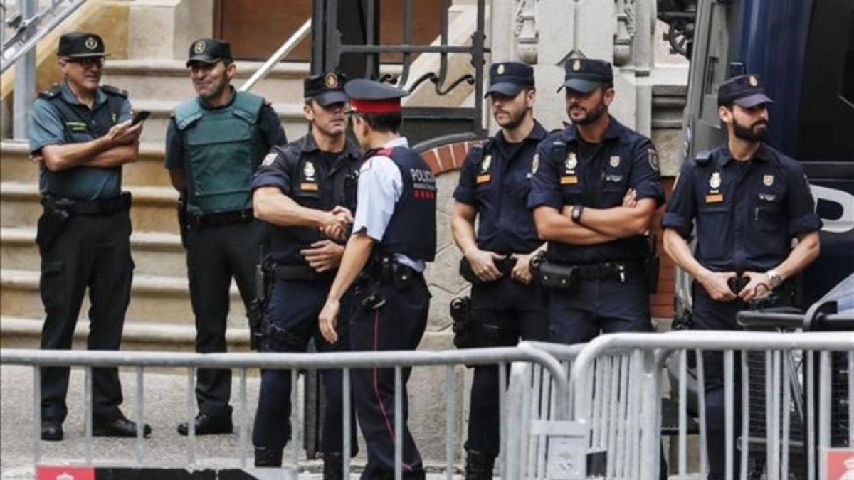 Agentes de los Mossos, la Guardia Civil y la Policía Nacional, en la Delegación del Gobierno en Cataluña-JULIO CARBO