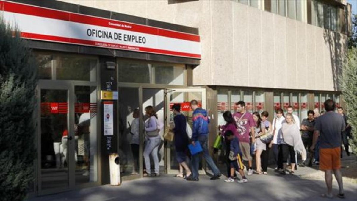 Cola de parados ante una oficina de empleo.-