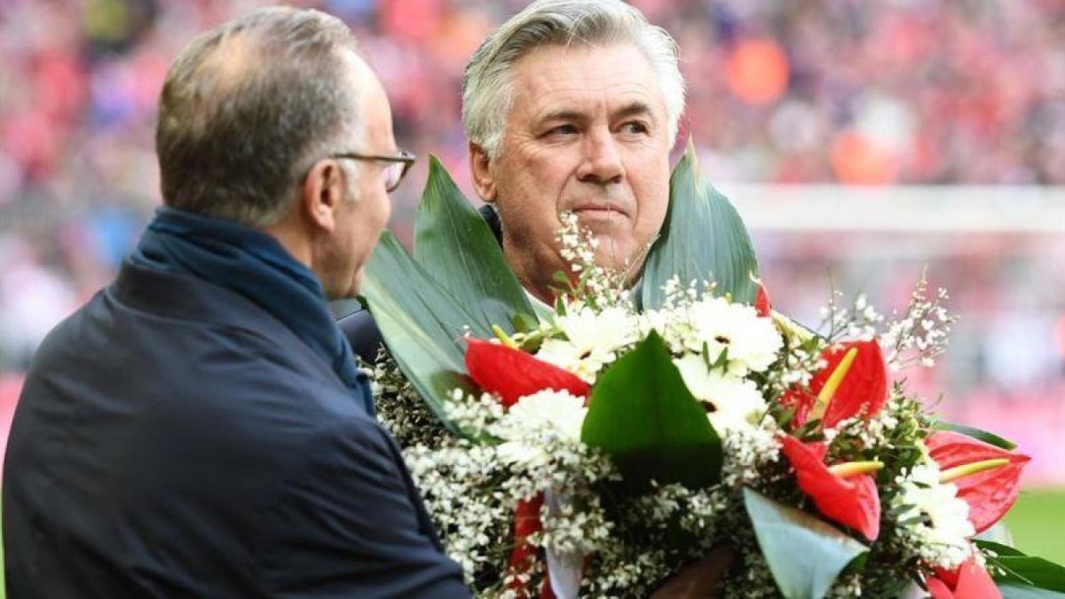 Ancelotti recibe un obsequio de Rummenigge por sus 1000 partidos en los banquillos.-REUTERS / LENNART PREISS