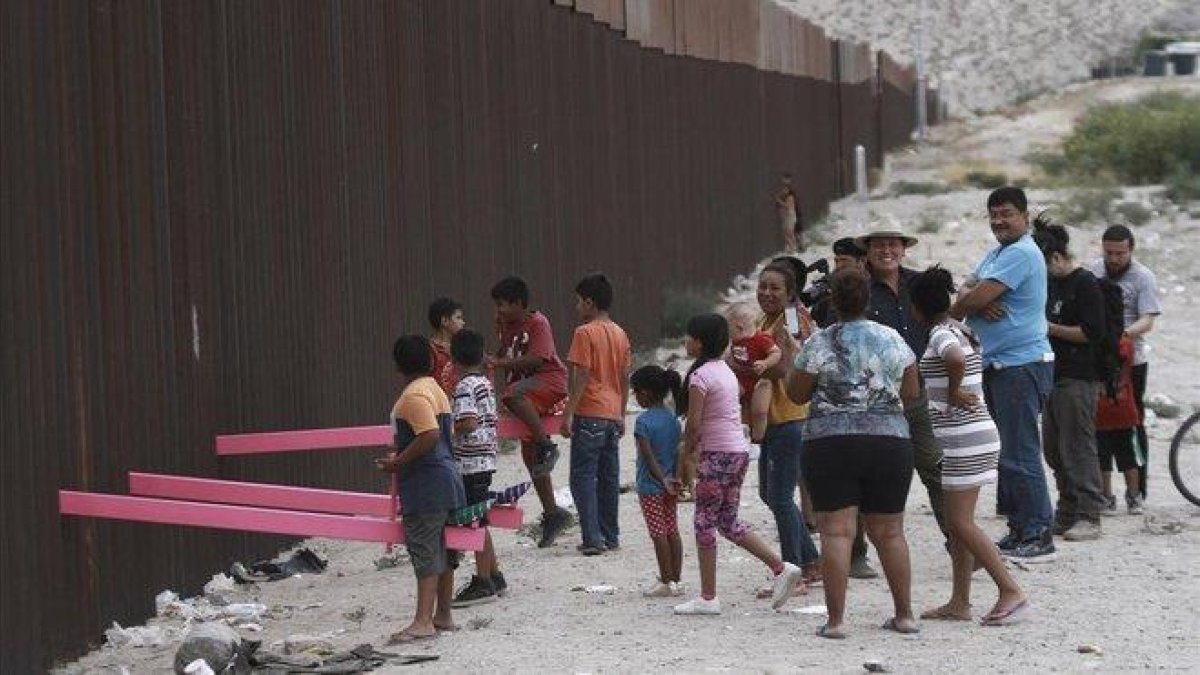 Niños juegan en un balancín situado en el muro de México a su paso por Ciudad Juarez.-CHRISTIAN CHAVEZ (AP)