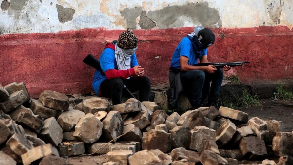 Miembros de las fuerzas gubernamentales sentados sobre lo que queda de las barricadas destruidas en el barrio de Monimbo /-OSWALDO RIVAS (REUTERS)