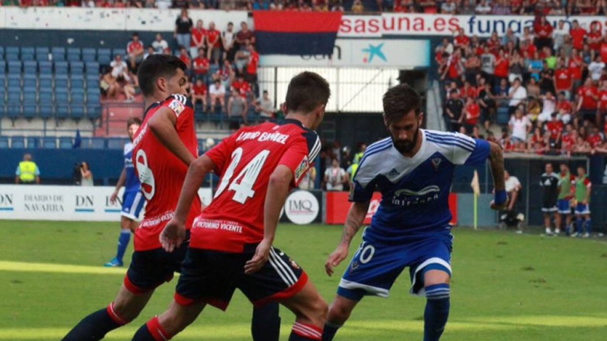 Fran Carnicer encara a dos defensores de Osasuna en el choque de ayer en El Sadar-Alfonso G. Mardones