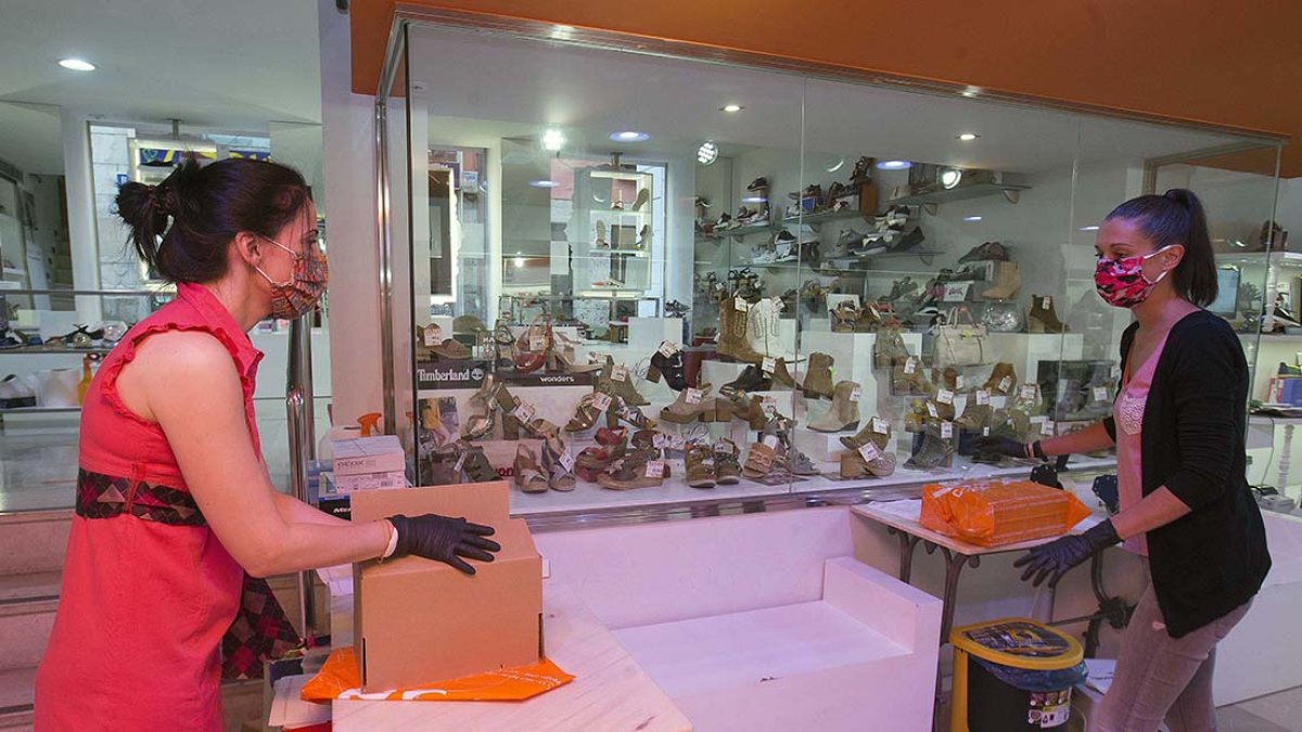 Dos empleadas de Calzados Vesga, en la Plaza Mayor, preparan los pedidos online. RAÚL. G. OCHOA