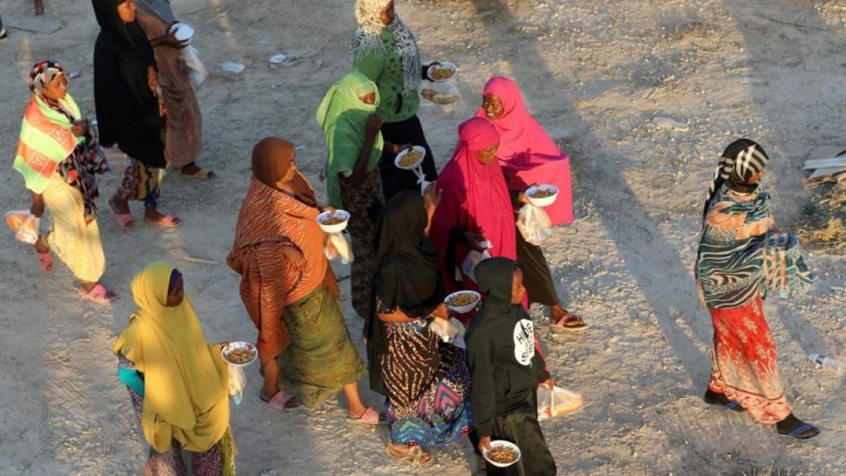 Unos inmigrantes caminan tras recibir comida en un centro de detención en Sabratha, el pasado 9 de octubre.-REUTERS / HANI AMARA