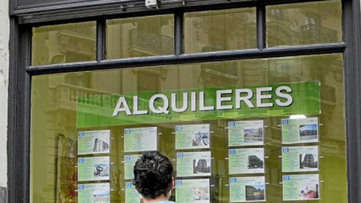 Un chico mira anuncios de viviendas en alquiler.-MITXI