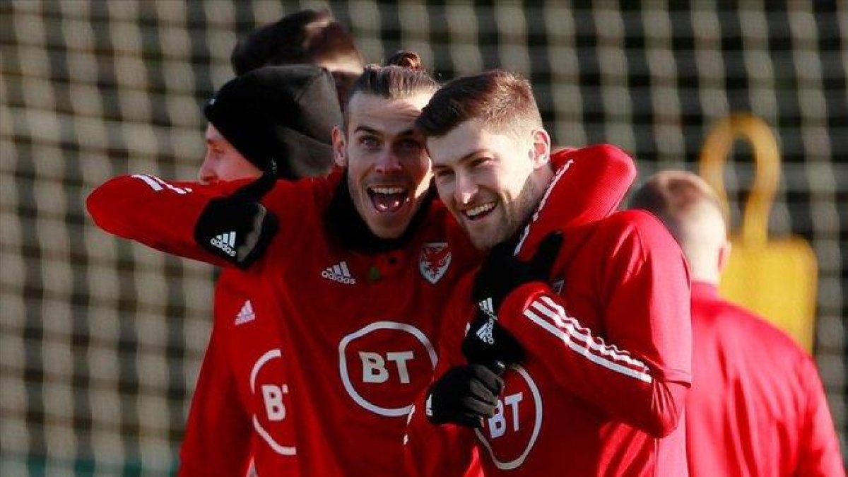 El madridista Gareth Bale (i) se abraza con Ben Davis en un entrenamiento de Gales de esta semana.-