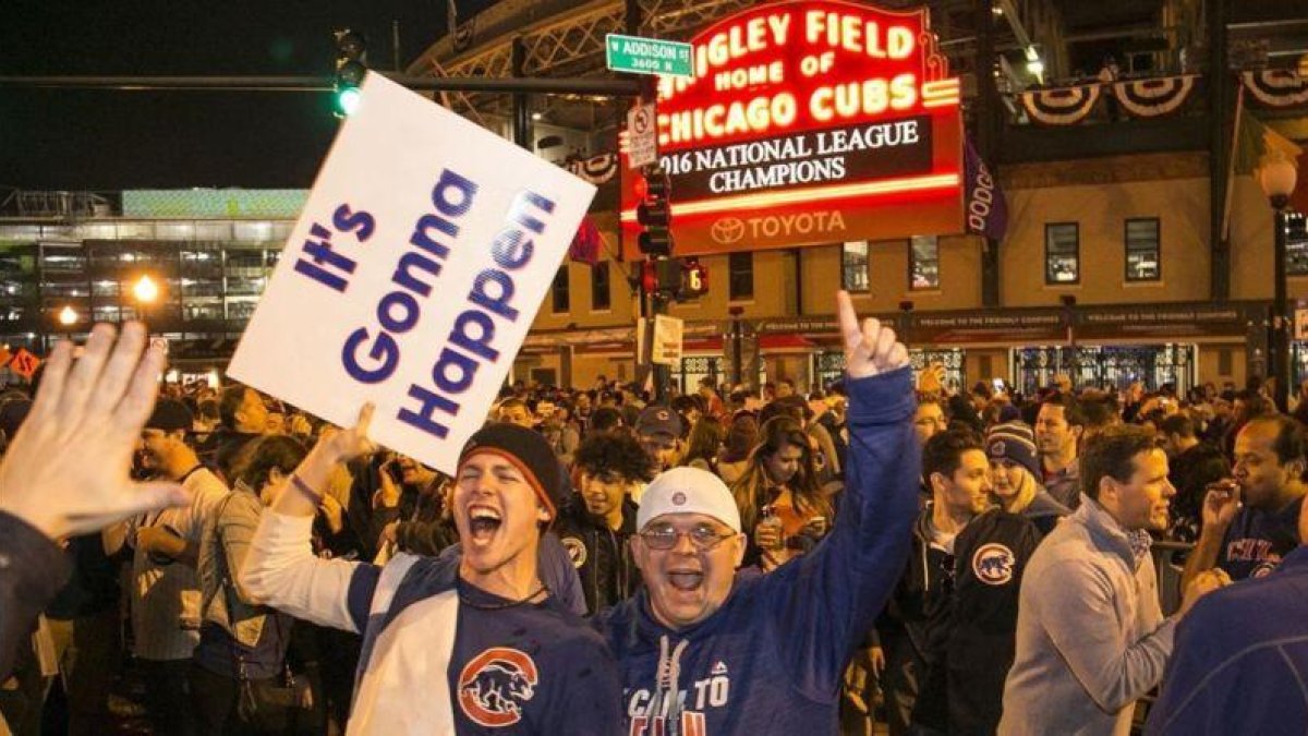 Aficionados de los Cubs celebran el sábado la victoria en la Liga Nacional junto al estadio Wrigley Field, en Chicago.-Ashlee Rezin
