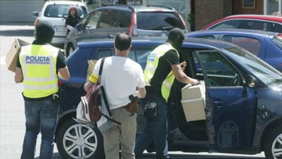Varios mossos se llevan cajas con material incautado en el Hotel Arrahona de Sabadell.-EFE / ANDREU DALMAU