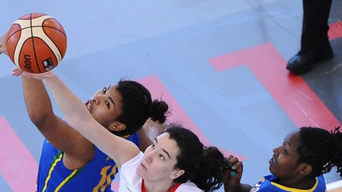 Sofía Galerón lucha por el rebote ante dos jugadoras de Brasil.-FEB