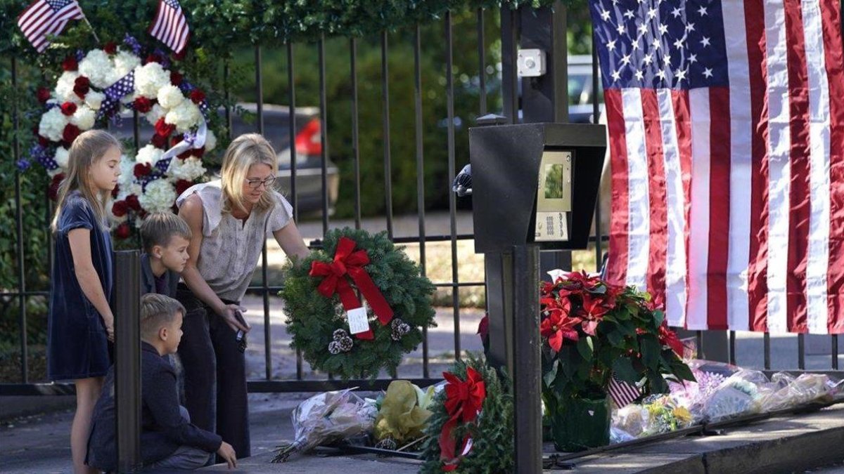 Tiffany Utterson y sus hijos Ella, Ian y Owen depositan una corona de flores en la puerta exterior de la residencia del expresidente George Bush, en Houston (Tejas) el 2 de diciembre del 2018. /-AP / DAVID J. PHILLIP