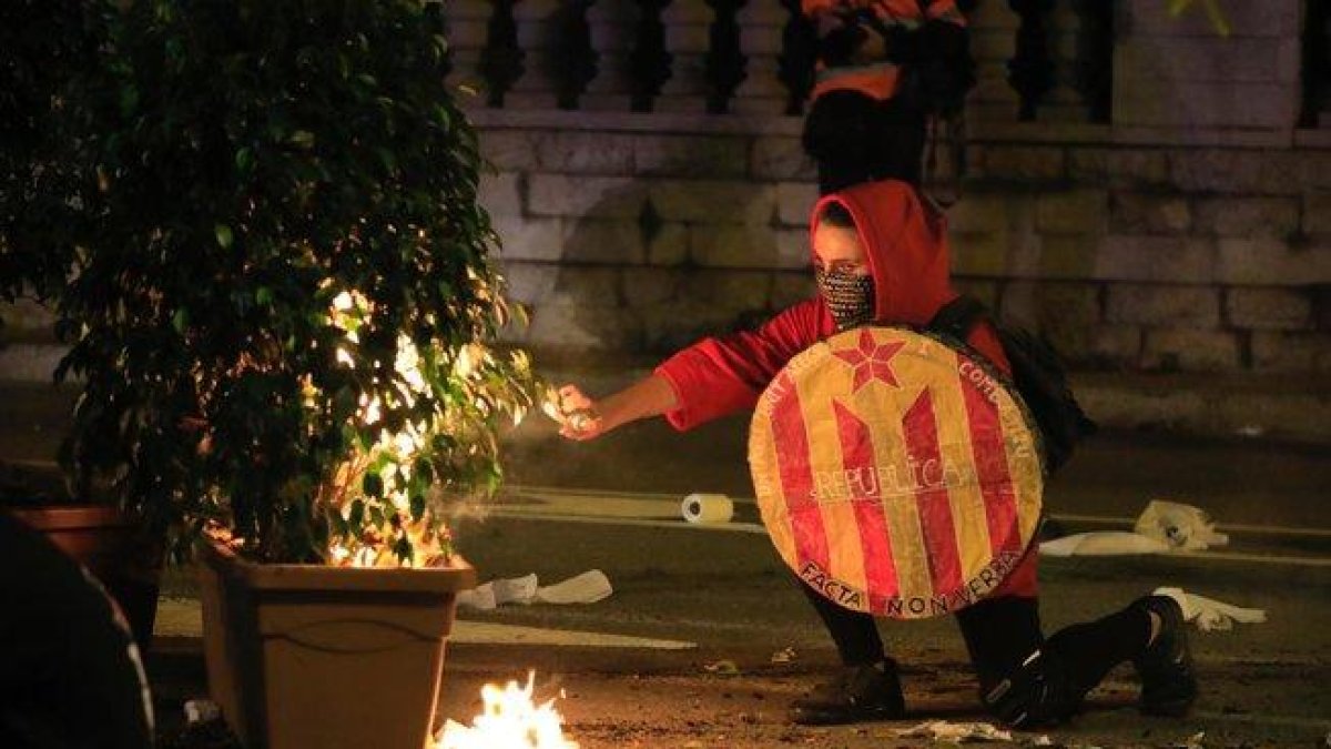 Uno de los manifestantes prendiendo fuego.-FERRAN NADEU