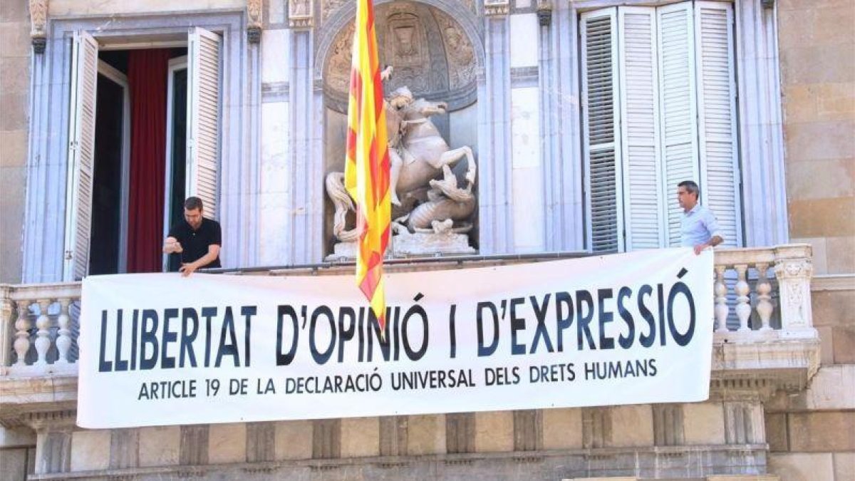 Miembros del equipo de Torra cuelgan una nueva pancarta en el Palau, tras retirar las dos anteriores: Libertad de opinión y expresión.-ACN / BERNAT VILARÓ