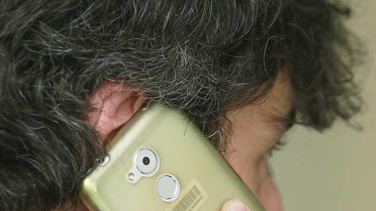 Un hombre habla por el teléfono móvil.-RAÚL G. OCHOA