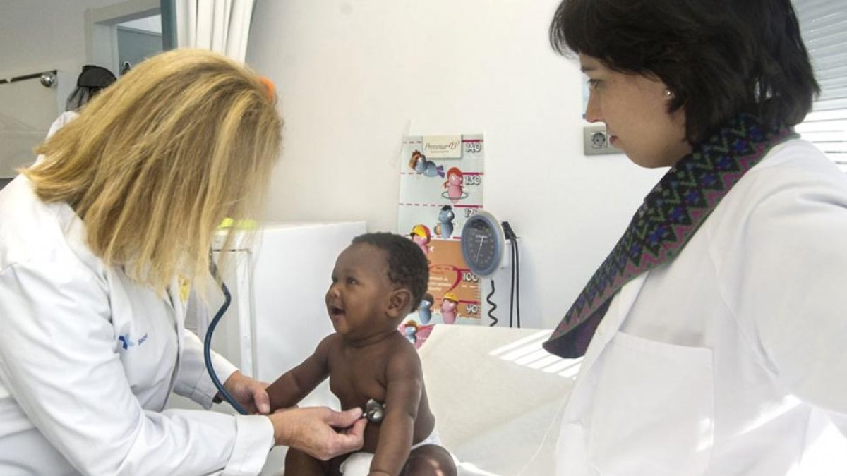 Una médico y una enfermera atienden ayer a un niño en un centro de salud de la capital.-Israel L. Murillo