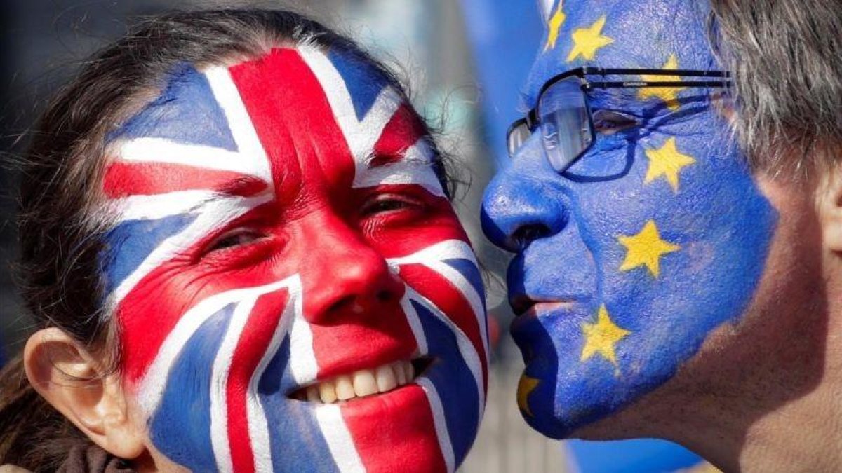 Dos activistas con las caras pintadas con la bandera británica y la de la Unión Europea participan en una manifestación contra el brexit en Bruselas.-EFE / OLIVIER HOSLET