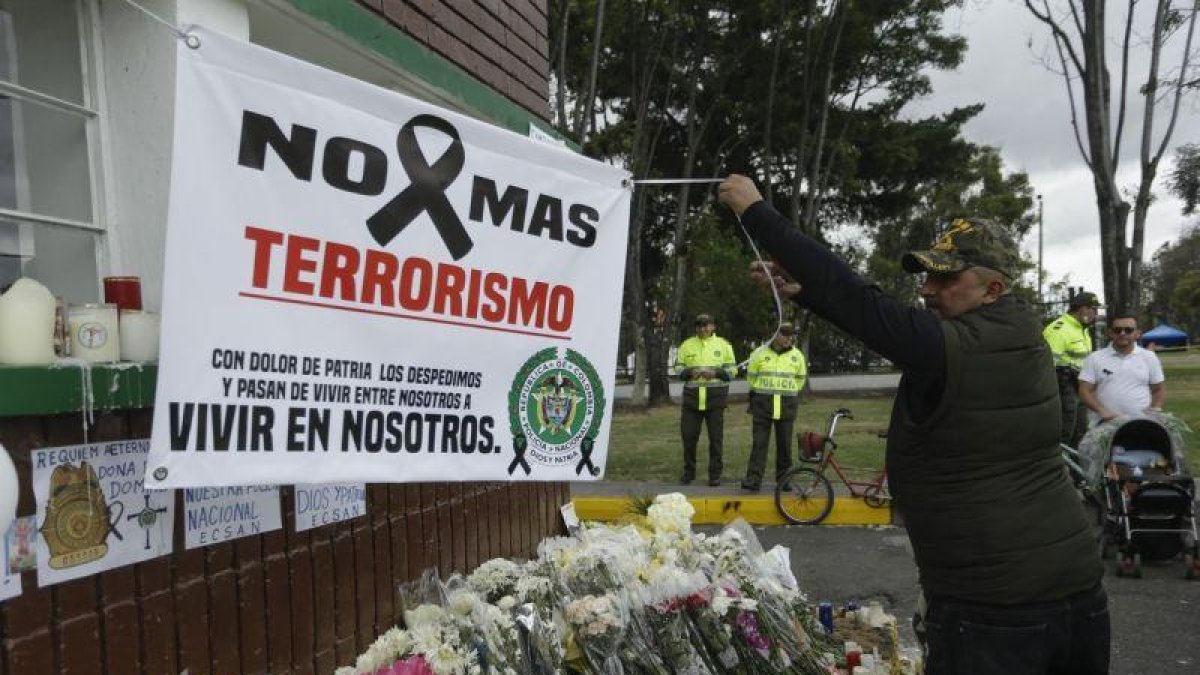 Un hombre extiende una pancarta durante un homenaje a los cadetes muertos por la explosion del carro bomba contra la Escuela de Cadetes de la Policia General Santander en un ataque atribuido a la guerrilla del ELN.-EFE